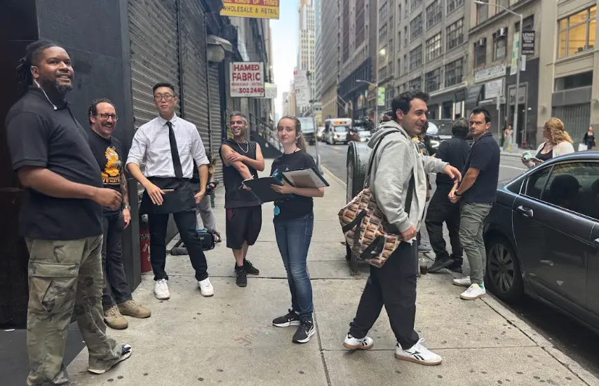 Cast and crew gather on a Midtown sidewalk