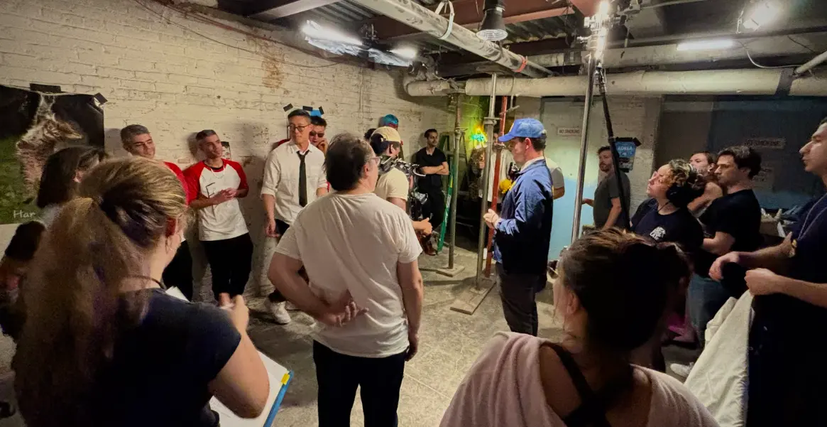 The full company gathers on the basement set