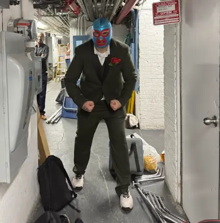 A masked performer waits backstage
